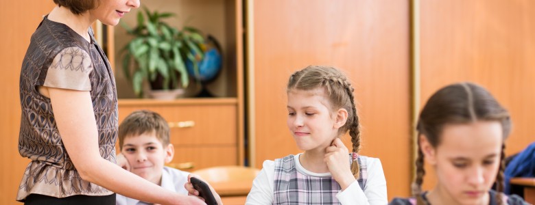 Teacher confiscating schoolkid's mobile phone at lesson